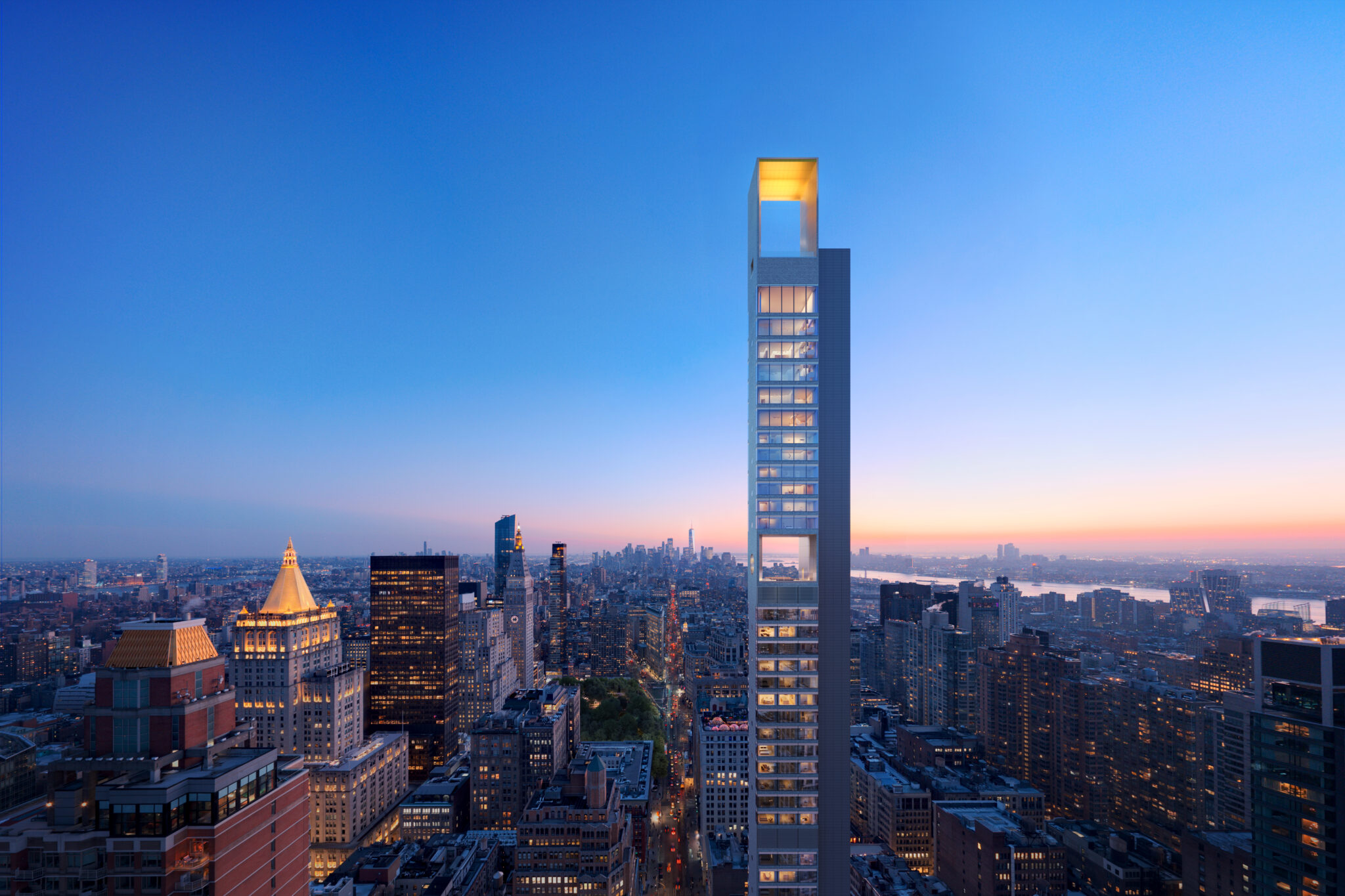 262 Fifth Avenue at dusk, its concave gold crown glowing above the NoMad skyline.